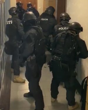 Policyjni antyterroryści w trakcie siłowego wejścia do mieszkania