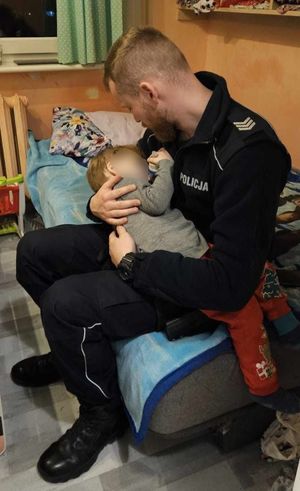 policjant z dzieckiem, które było pozostawione bez opieki